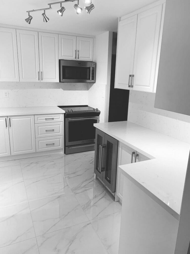 White kitchen cabinets with ceiling lights on top give the kitchen in Scarborough,Toronto a nice appearance after the remodelling by Desa Contracting, Restoration, and Janitorial Services