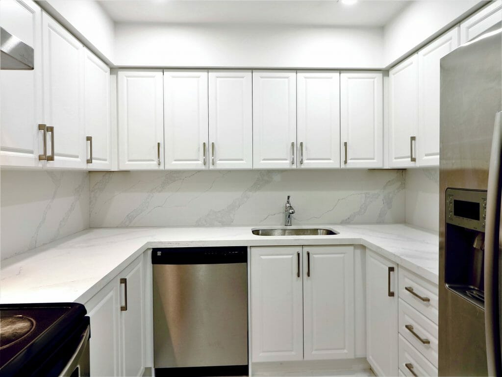 White cabinets with dazzling ceiling lights are featured in the newly renovated kitchen at 1300 Islington Condo.