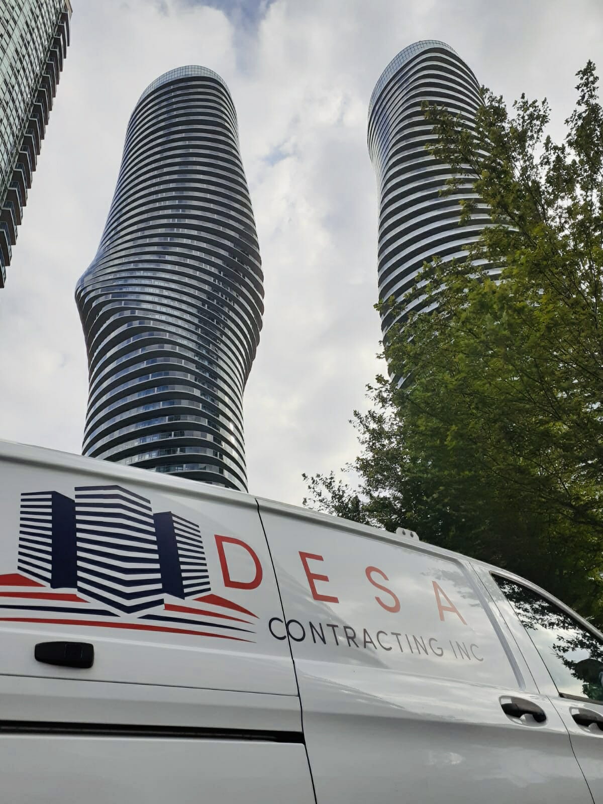 A Desa Contracting and Restorations vehicle is shown against a backdrop of Toronto buildings in this image.