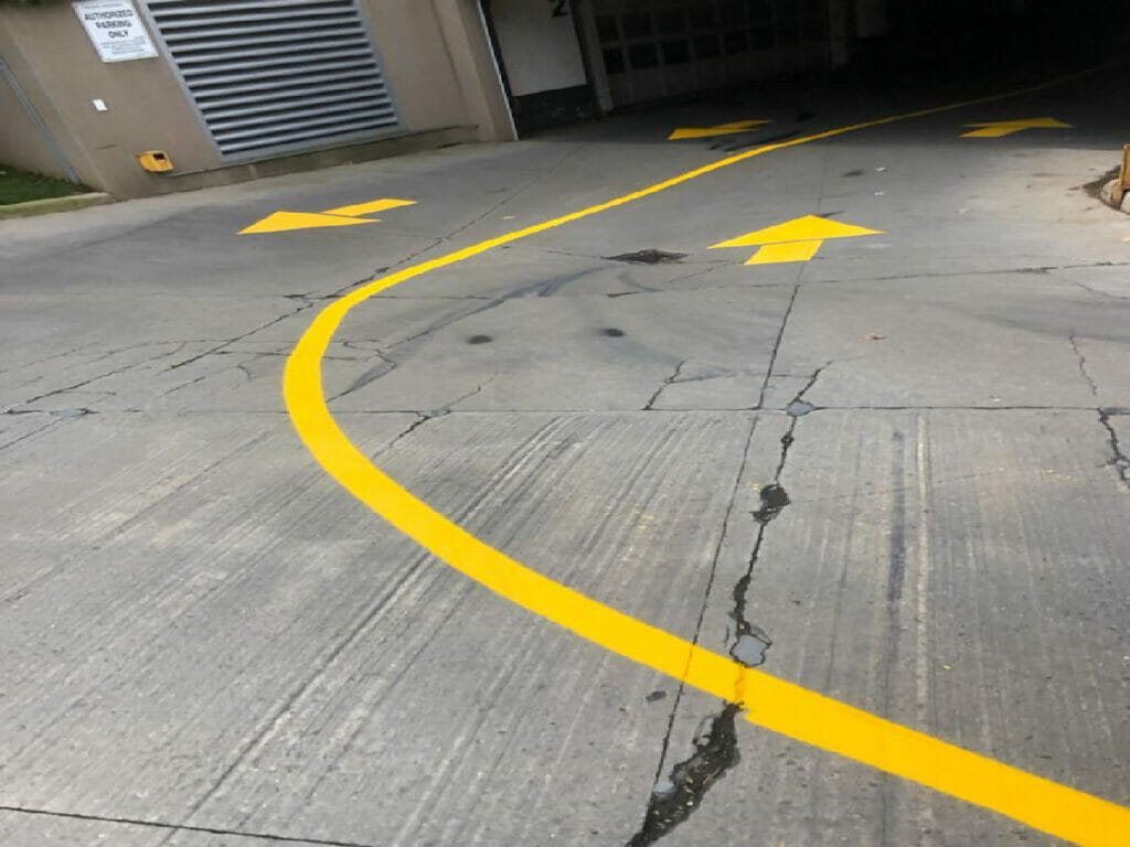 Desa Contracting, Restoration, and Janitorial Services recently painted direction arrows serve as signs for vehicles to travel to and from their respective parking spaces at a condo in Toronto.