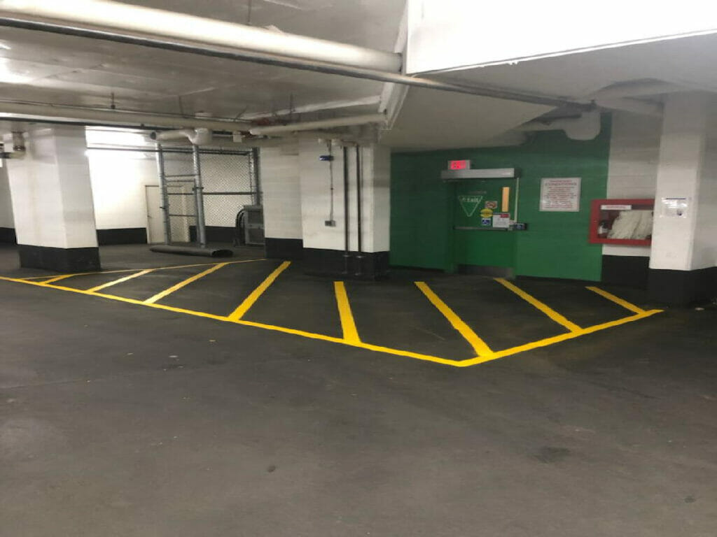 Paintings of parking lots by Toronto's Desa Contracting, Restoration, and Janitorial Services can be found in the underground parking area of a condominium building.