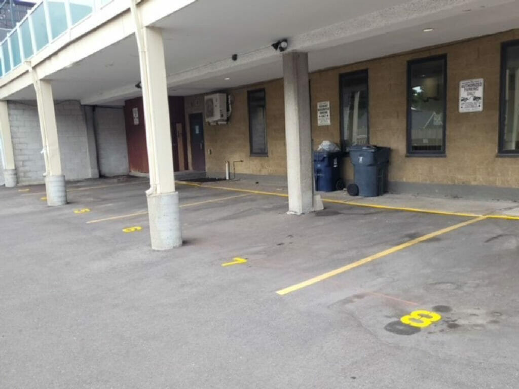 Desa Contracting, Restoration, and Janitorial Services's depiction of a parking place with two pillers and parking lights beneath a condo in Toronto.