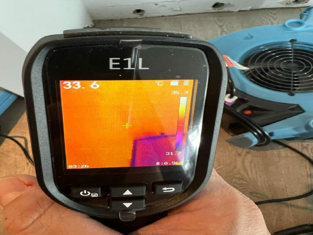 This image displays a water restoration moisture meter being held by a specialist from Desa Contracting and Restoration inside a Toronto residence.