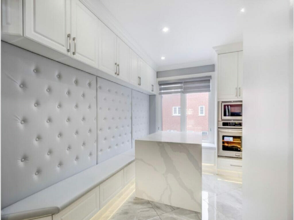 Recently, Desa Contracting and Restoration completed a home improvement project in Toronto, which involved renovating the kitchen. The updated kitchen now boasts a microwave, ample cabinet space, a spacious window, and a cozy wall sitting area with comfortable cushions and additional cabinets.