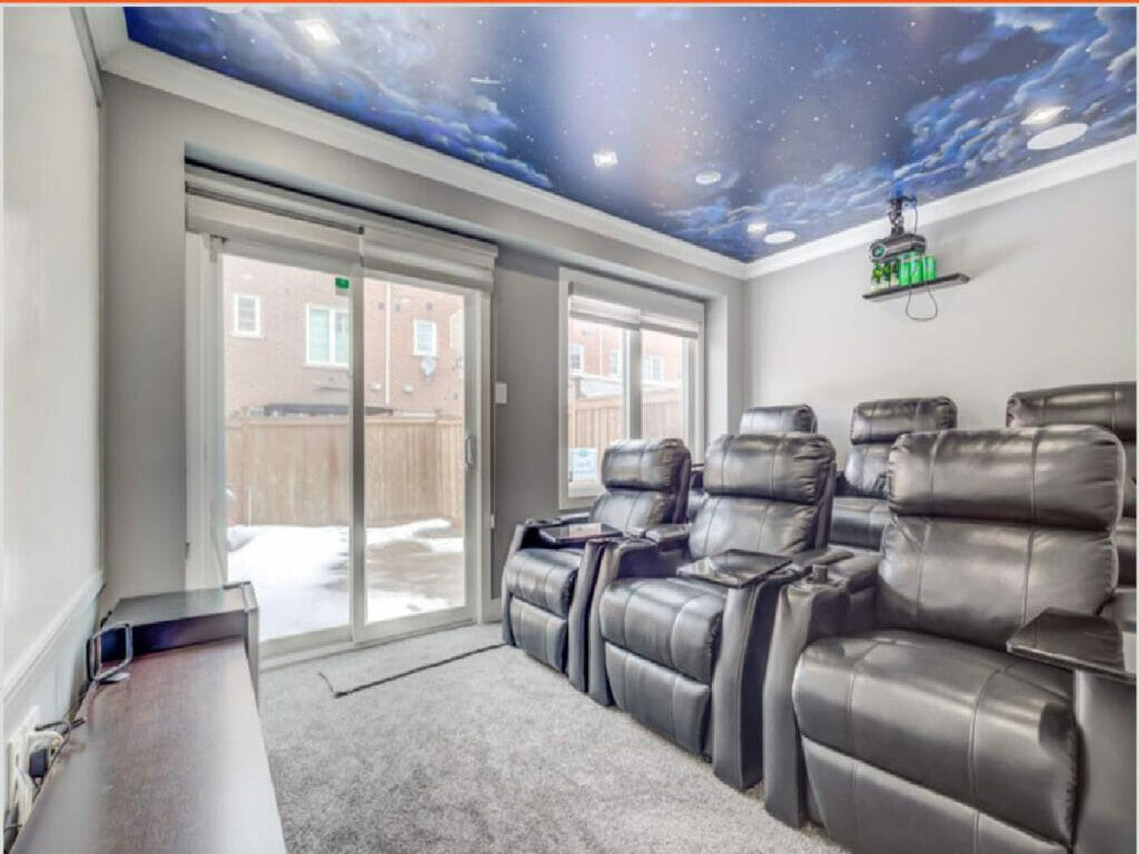 Desa Contracting and Repair, based in Toronto, renovated a house featuring a home theater room along with six recliner seats and a galaxy ceiling painting along with a huge door and windows
