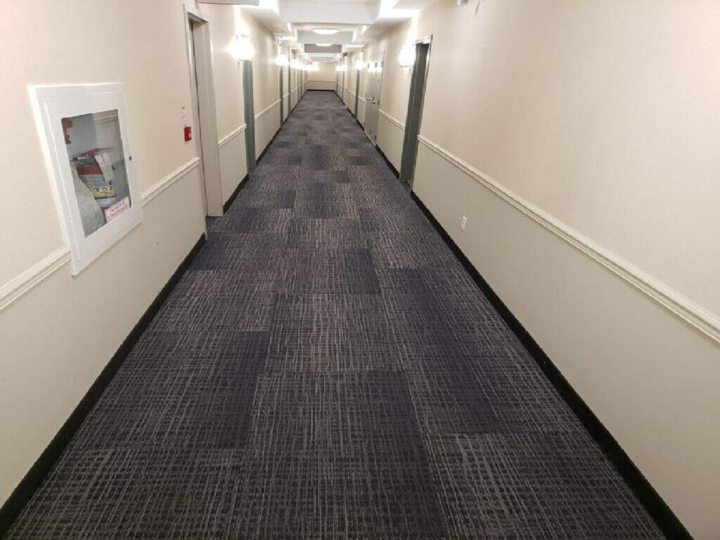Featuring a Long Clean Hallway with Ceiling Lights after renovaton by Desa Contracting,Restoration and Janitorial Services in Toronto.