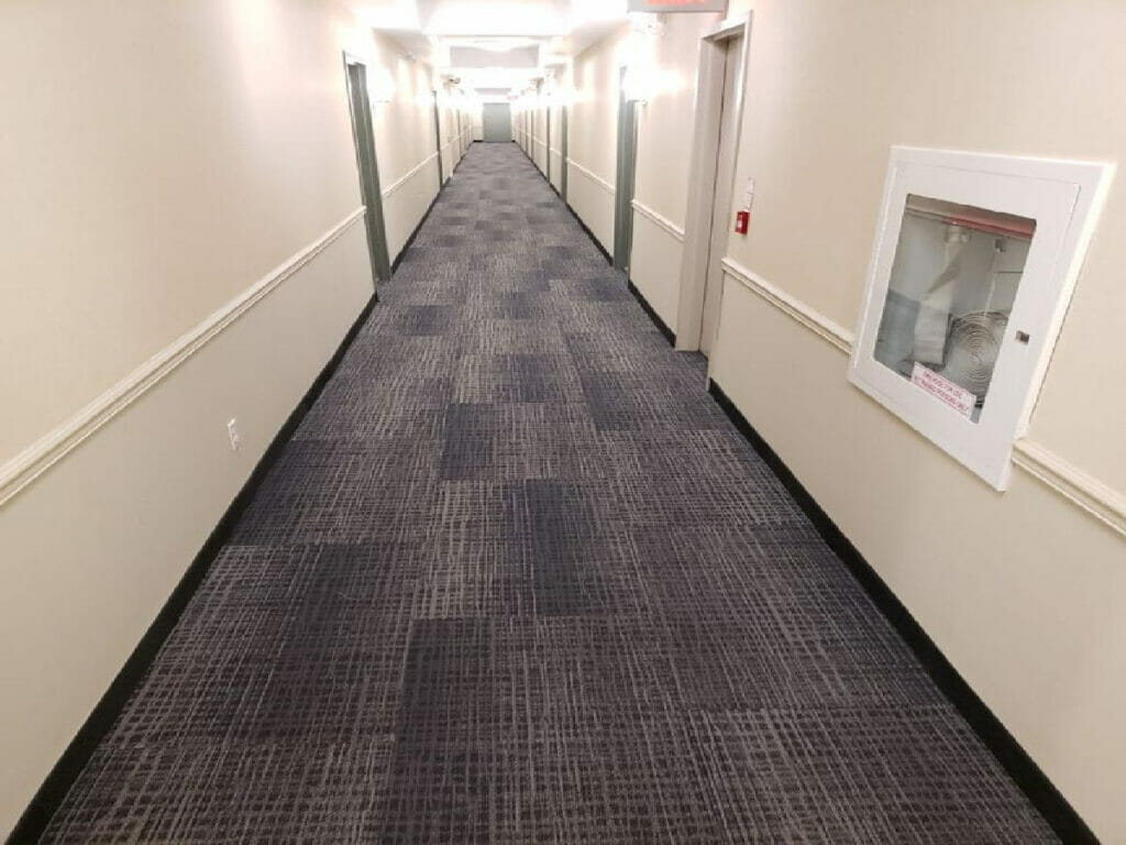 After renovation by Desa Contracting, Restoration, and Janitorial Services, it has a long, spotless hallway with ceiling lights.