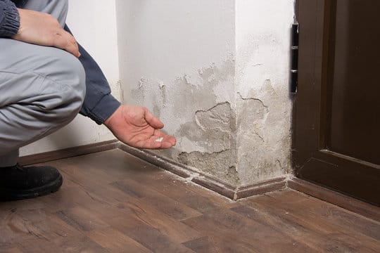 Hidden Water Damage on Walls being checked by a man